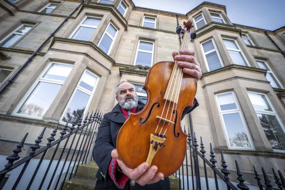 Edinburgh based luthier and nature conservationist Steve Burnett holds the Ernest Shackleton Driftwood Violin (Jane Barlow/PA)