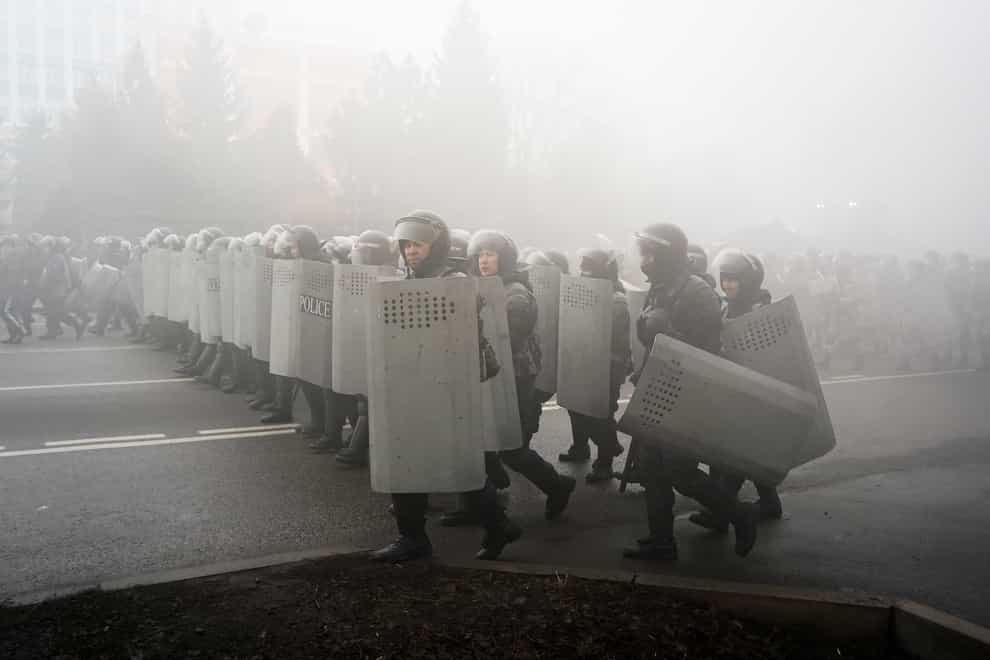 Riot police walk to block demonstrators during a protest in Almaty, Kazakhstan (Vladimir Tretyakov/AP)