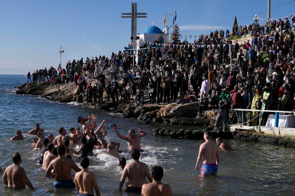 Pilgrims jump to catch the cross during a water blessing ceremony marking the Epiphany celebrations at Piraeus port, near Athens (Thanassis Stavrakis/AP)