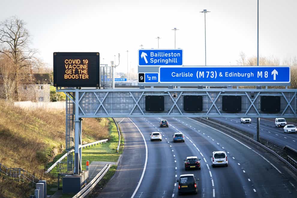 Information signs above the M8 motorway in Glasgow saying ‘Covid 19 Vaccine Get the Booster’ (Jane Barlow/PA)