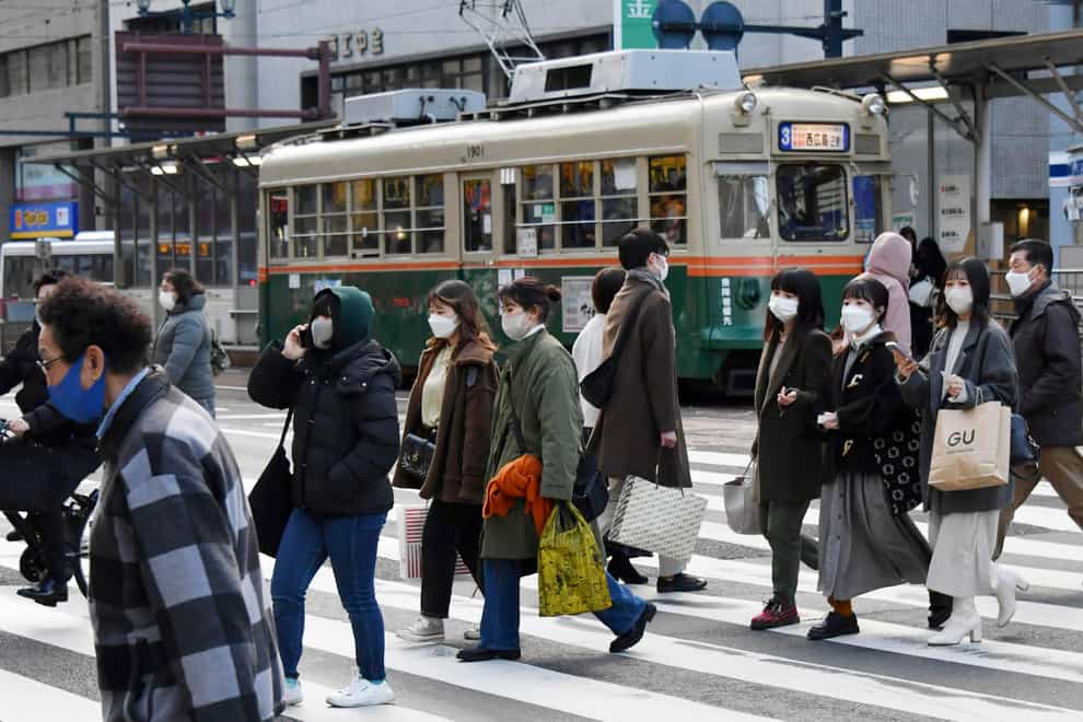People wearing face masks cross a street in Hiroshima (AP)