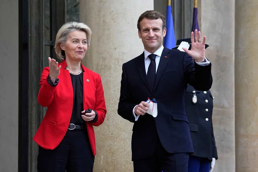 French President Emmanuel Macron waves as he greets European Commission president Ursula von der Leyen at the Elysee Palace in Paris (Michel Euler/AP)