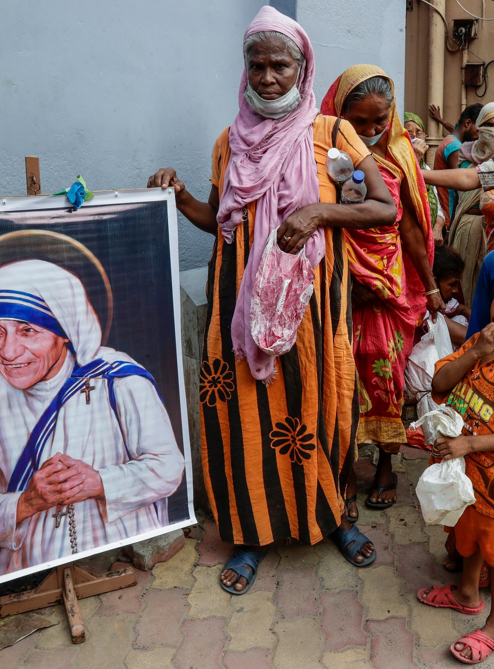 Homeless people gather beside a portrait of Saint Teresa (AP)