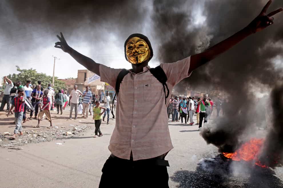 A man flashes the victory sign during a protest to denounce the 2021 military coup, in Khartoum, Sudan (Marwan Ali/AP)