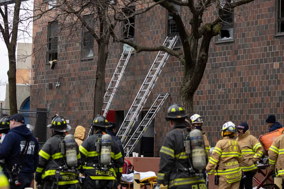 Firefighters use ladders to gain access to the apartment building in the Bronx where 19 people died (AP Photo/Yuki Iwamura)
