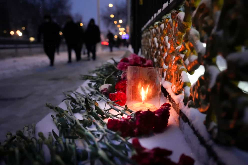 Flowers and candles left in memory of victims of the protests at the fence of the Kazakhstan embassy in Moscow (Alexander Zemlianichenko/AP)