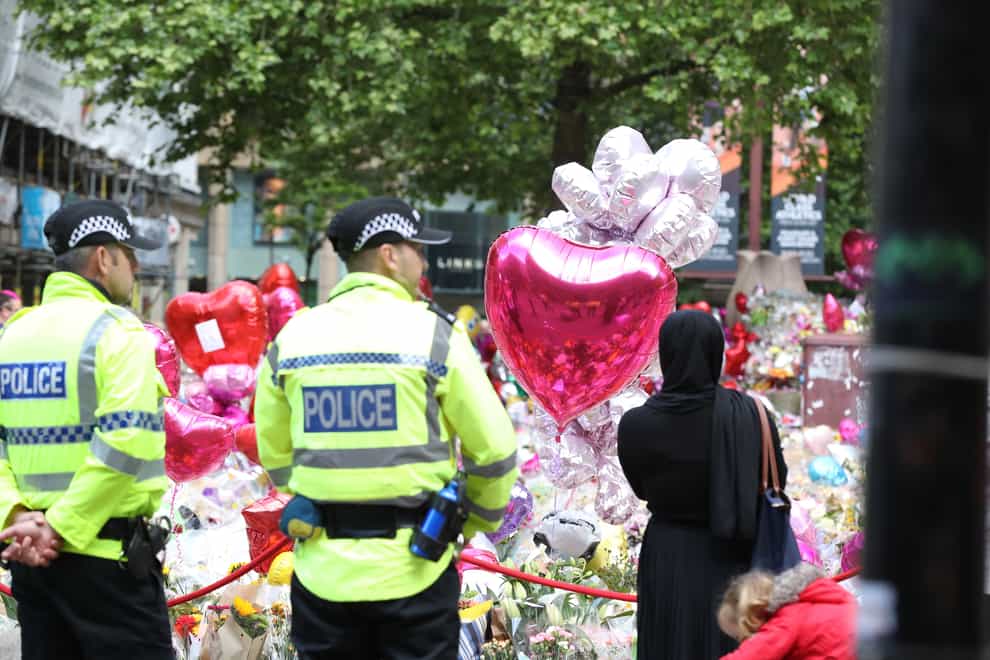 People look at flowers and tributes left in St Ann’s Square in Manchester ahead of a benefit concert for the victims of the Manchester Arena terror attack (Owen Humphreys/PA)