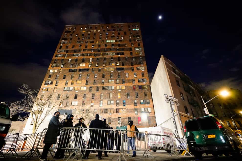 Police stand by barricades outside the apartment building (AP)
