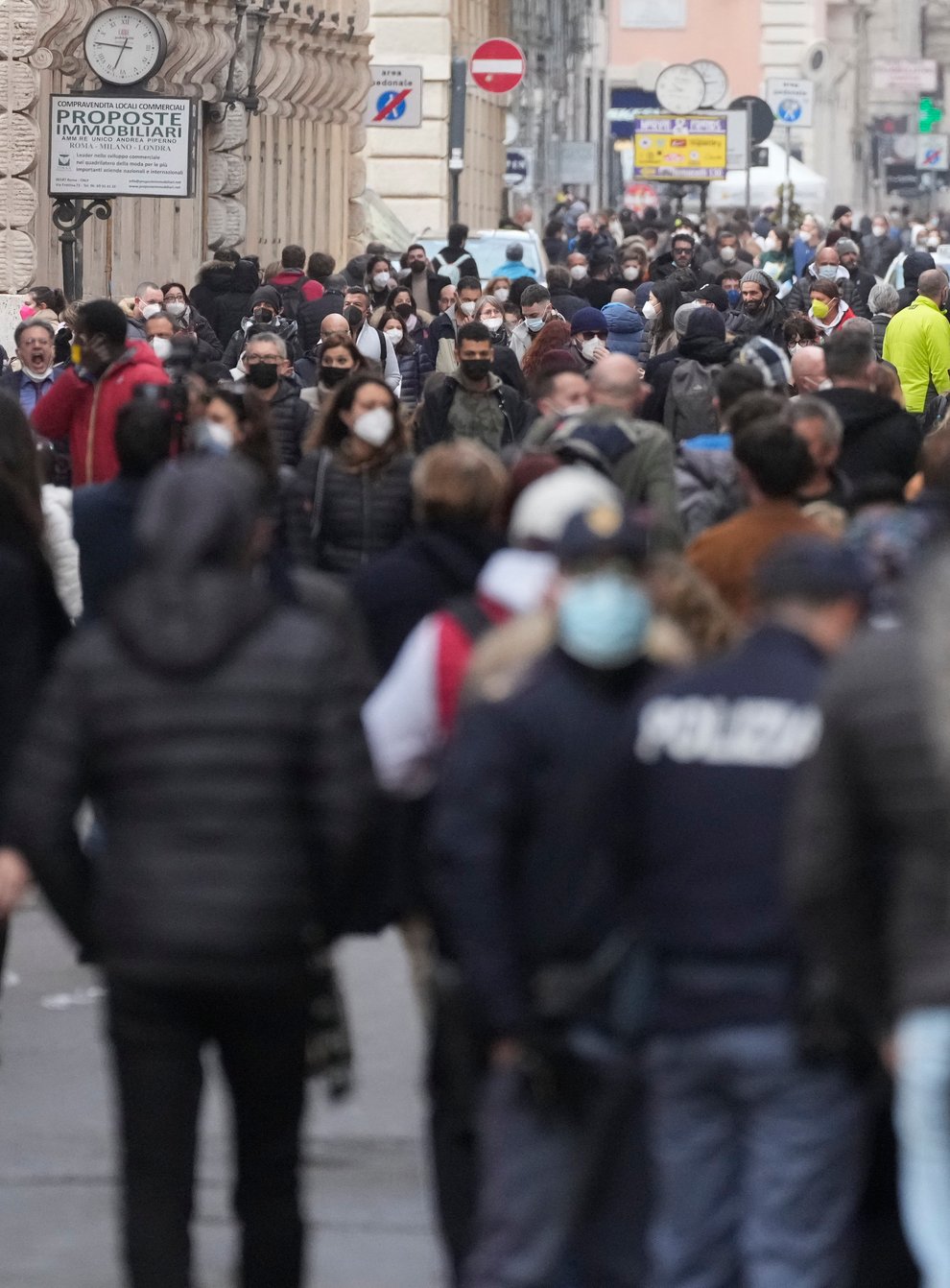 FILE – People stroll along the Via del Corso avenue in Rome, on Jan. 5, 2022. New coronavirus restrictions have gone into effect in Italy that amounted to a near-lockdown for the unvaccinated. As of Monday, proof of vaccination or a recent infection is required to access public transport, coffee shops and a host of other activities.The new “super” health pass requirement, which eliminates the ability to access services with just a negative test, coincided with the return to work and school for many Italians after the Christmas and New Year holiday. (AP Photo/Gregorio Borgia)