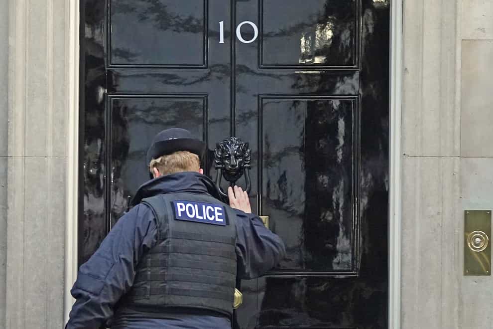 A police officer knocks on the door of the Prime Minister’s official residence in Downing Street, as public anger continues following the leak on Monday of an email from Boris Johnson’s principal private secretary, Martin Reynolds, inviting 100 Downing Street staff to a “bring your own booze” party on May 20, 2020 (Stefan Roussea/PA)
