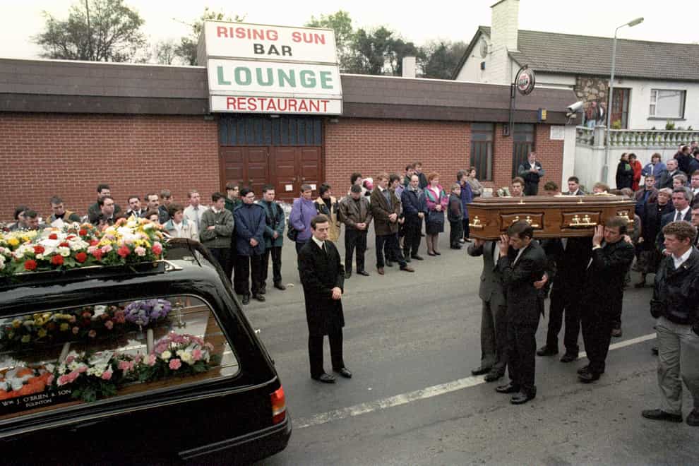 The coffin of Steven Mullan is led past the Rising Sun Bar at Greysteel, Londonderry (PA)