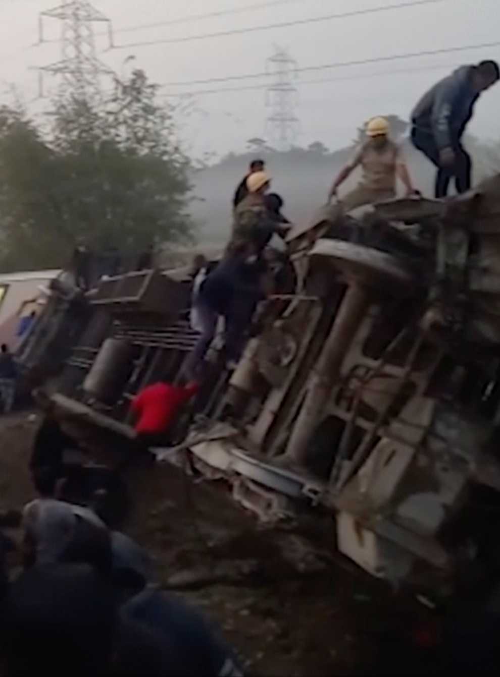 Rescuers look inside derailed coaches after the accident in Jalpaiguri, West Bengal state (KK Productions/AP)