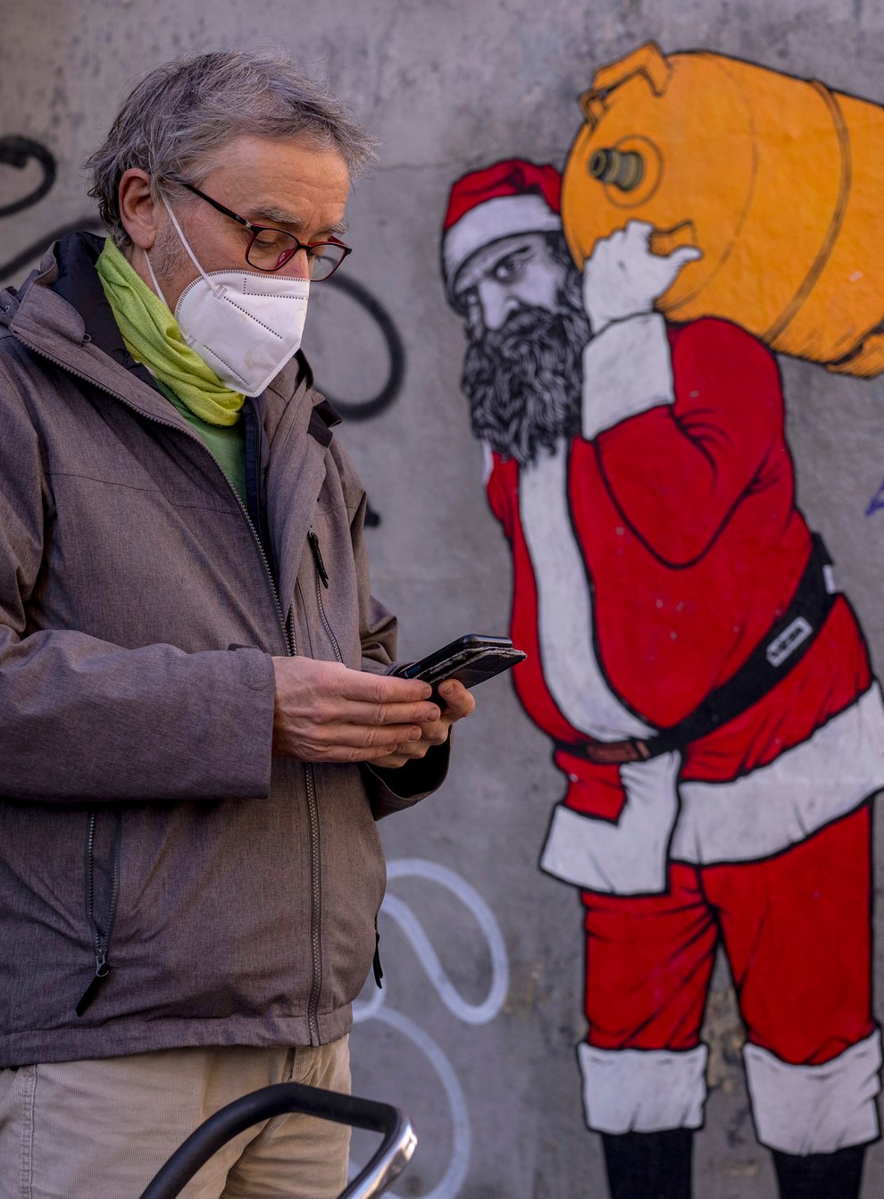 A man and woman wearing FFP2 masks to curb the spread of Covid-19 are seen in front of a mural depicting Santa Claus, in Madrid, Spain (AP)