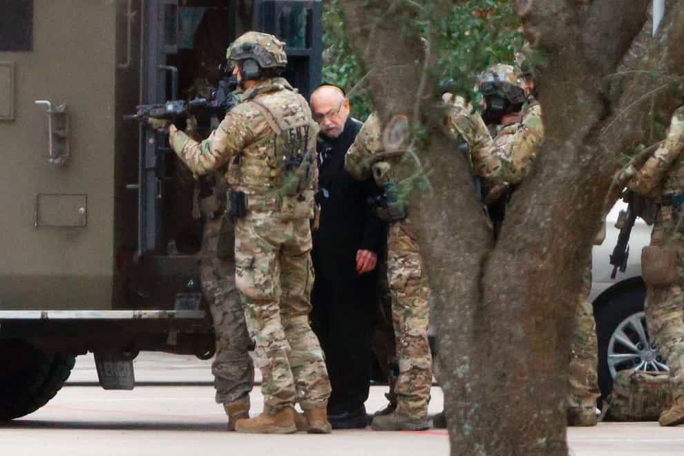 Authorities escort a hostage out of the Congregation Beth Israel synagogue in Colleyville, Texas (Elias Valverde/The Dallas Morning News via AP)