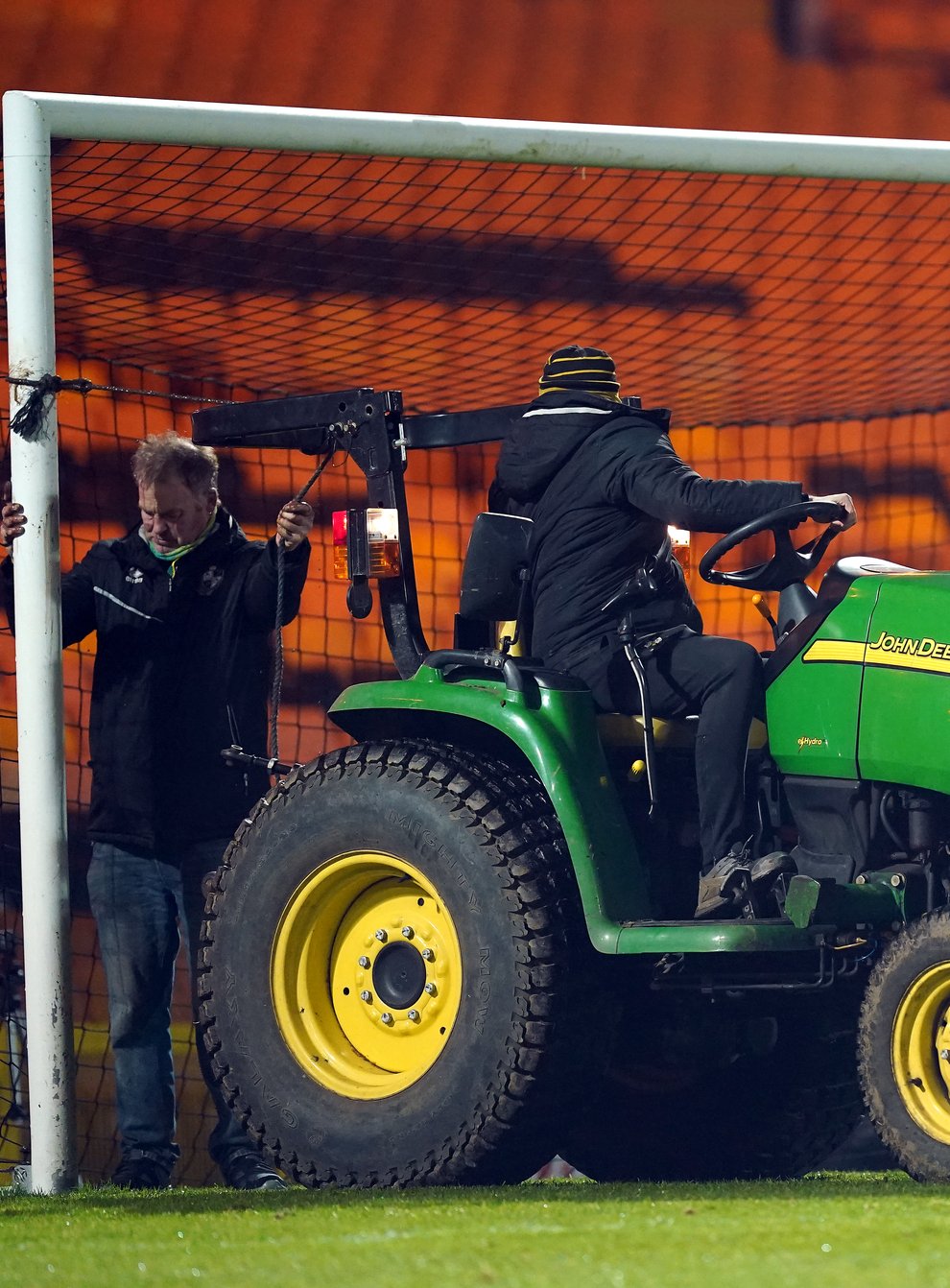 Groundstaff repair the goalposts using a tractor as referee James Bell looks on (Mike Egerton/PA)