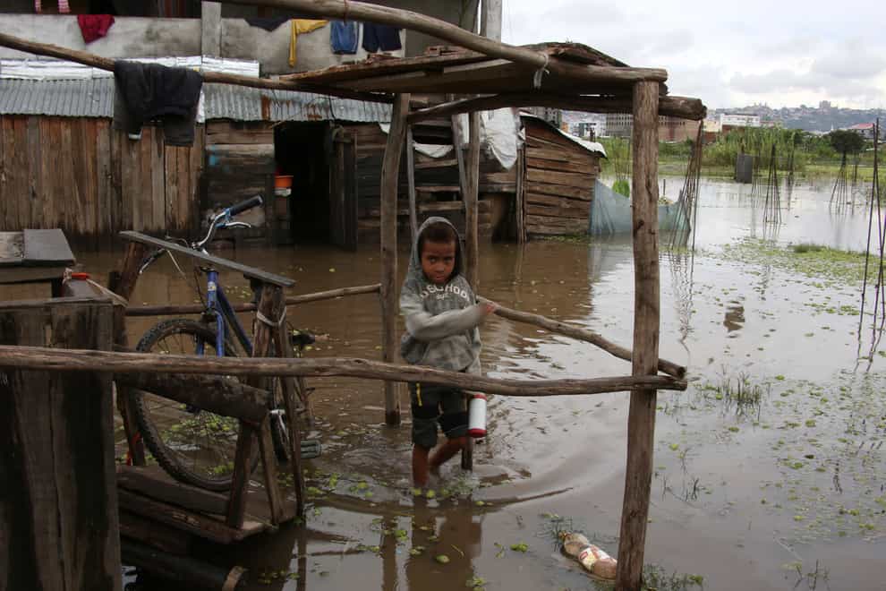 A child wades through flood water (Alexander Joe/AP)