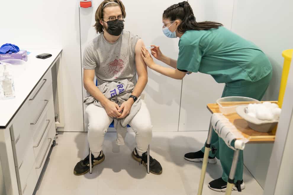 Simran Saughall administers a booster vaccine to Adam Hamilton at a Covid vaccination centre at Elland Road in Leeds (Danny Lawson/PA)