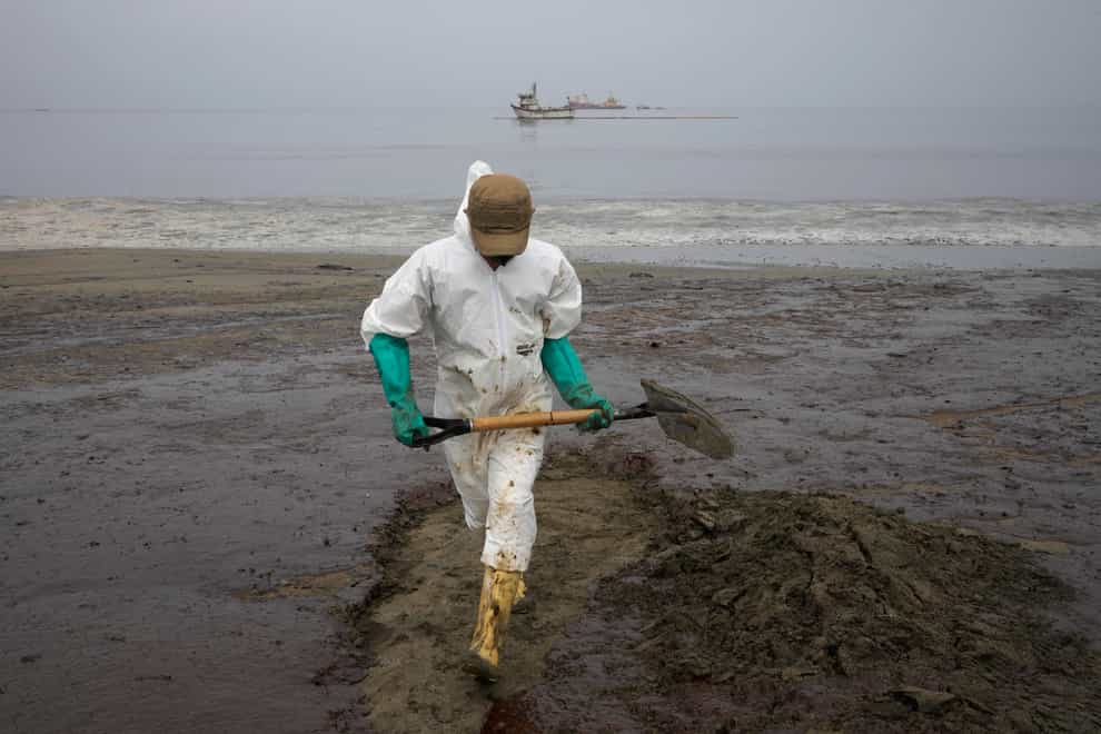 A worker cleans Conchitas Beach in Ancon, Peru (AP)