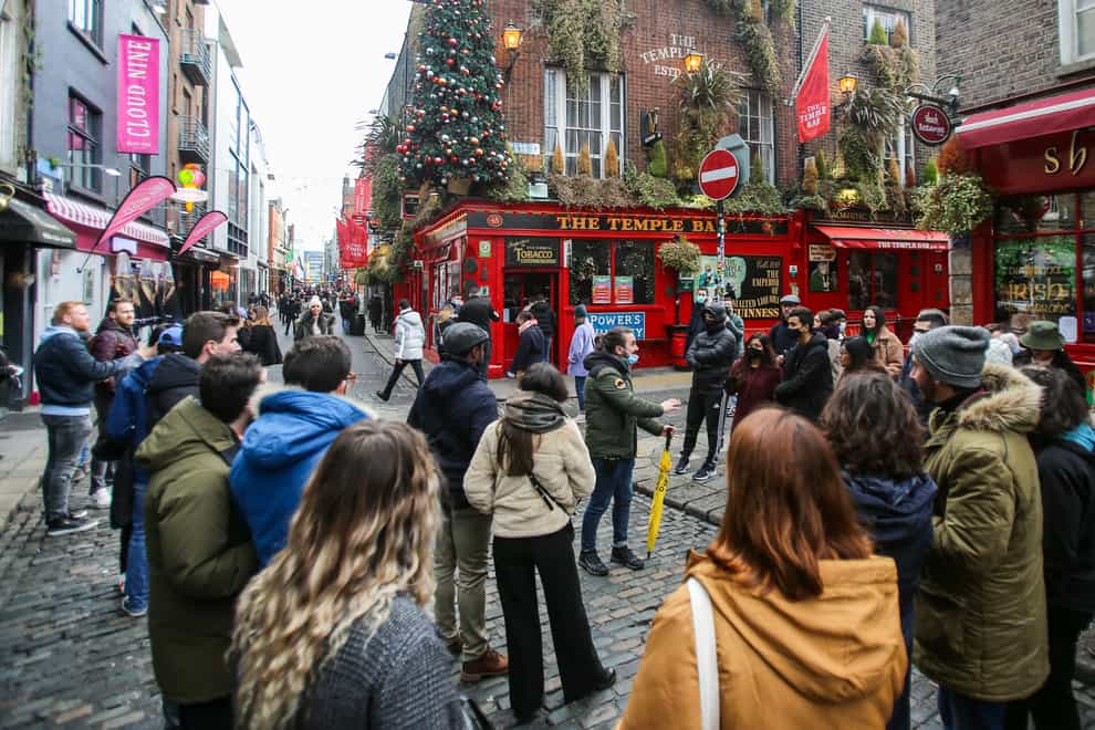 A tour group leader stops with tourists at the Temple Bar in Dublin on the day coronavirus restrictions were eased across Ireland (PA)