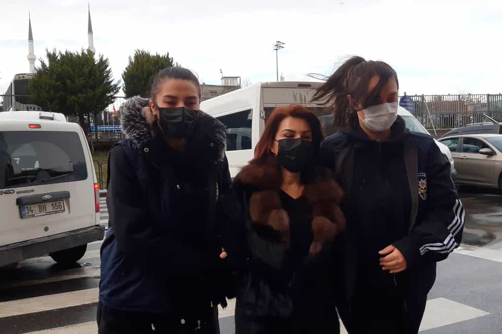 Police officers escort Sedef Kabas, a well-known Turkish journalist, before her appearance at court in Istanbul (AP)