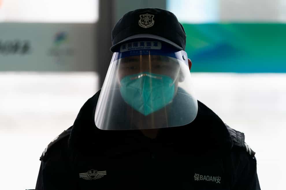 A security guard with a hazy face shield stands near the entrance of the main media centre at the 2022 Winter Olympics, Monday (Jae C Hong/AP)