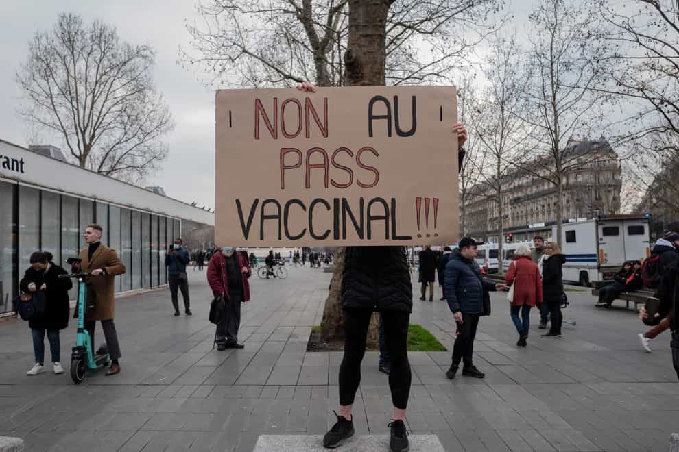 A demonstrator holds a placard that reads ‘No to vaccine pass’ during a rally in Paris, France (Rafael Yaghobzadeh/AP)