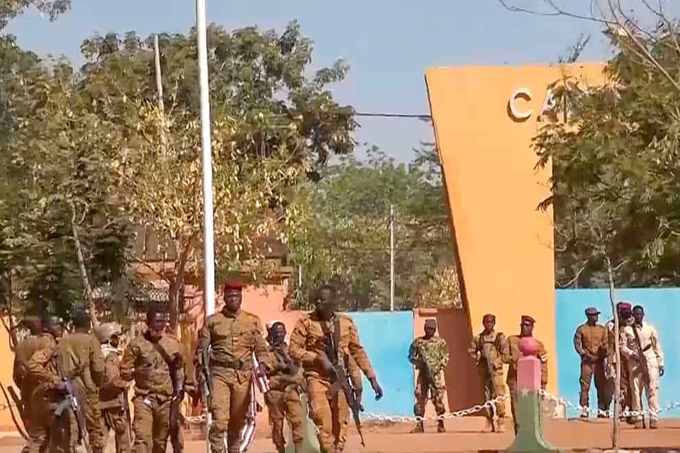 In this image made from video, mutinous Burkina Faso soldiers walk outside the Guillaume Ouedraogo military camp in Ouagadougou (AP)