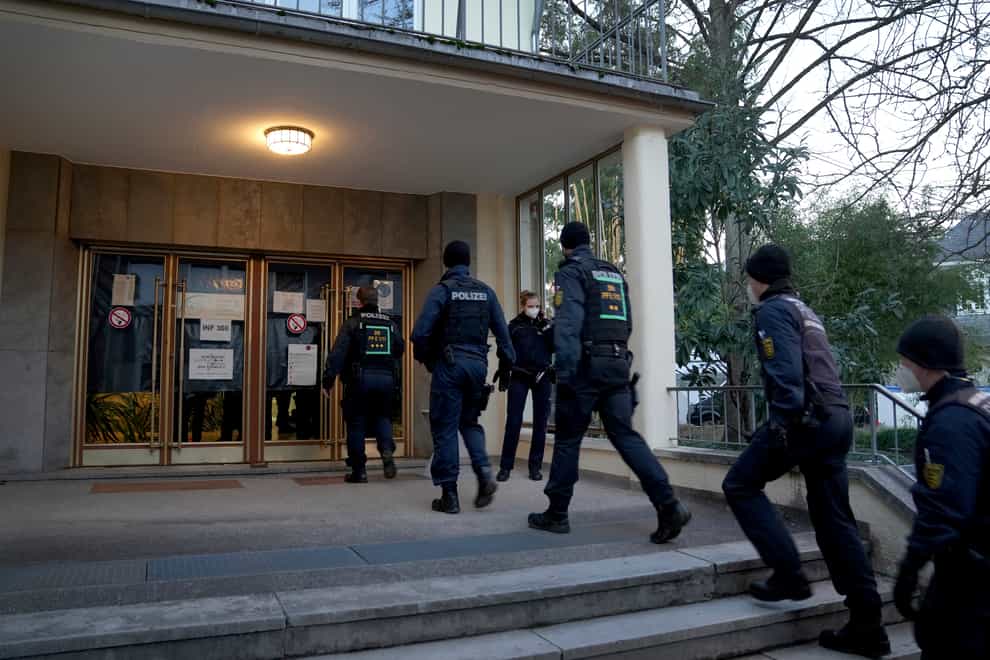 Police officers enter the crime scene on the grounds of the Heidelberg University (Michael Probst/AP)
