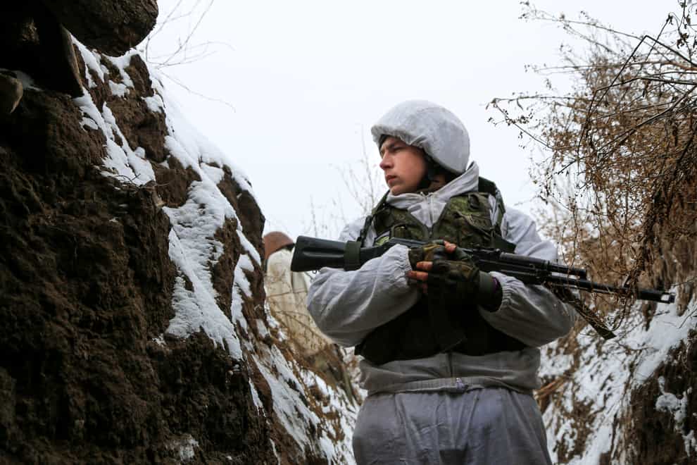A serviceman stands in a trench on the territory controlled by pro-Russian militants near frontline with Ukrainian government forces in Slavyanoserbsk, Luhansk region, eastern Ukraine, Tuesday, Jan. 25, 2022. Ukraine’s leaders sought to reassure the nation that a feared invasion from neighboring Russia was not imminent, even as they acknowledged the threat is real and prepared to accept a shipment of American military equipment Tuesday to shore up their defenses. (AP Photo/Alexei Alexandrov)