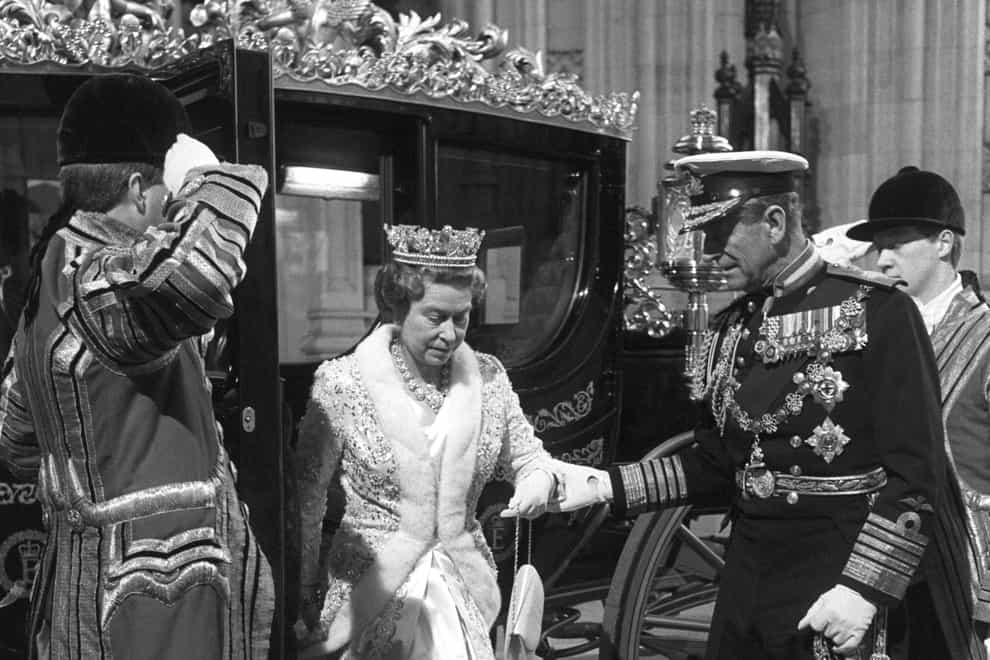The Duke of Edinburgh helps the Queen alight from the Australia State Coach at the State Opening in 1988 (David Jones/PA)