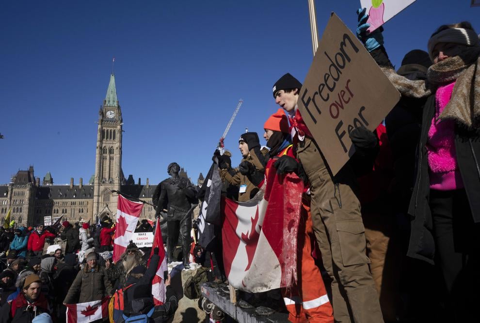 Protesters participating in a cross-country truck convoy protesting measures taken by authorities to curb the spread of COVID-19 and vaccine mandates gather near Parliament Hill in Ottawa on Saturday (Adrian Wyld/The Canadian Press via AP).