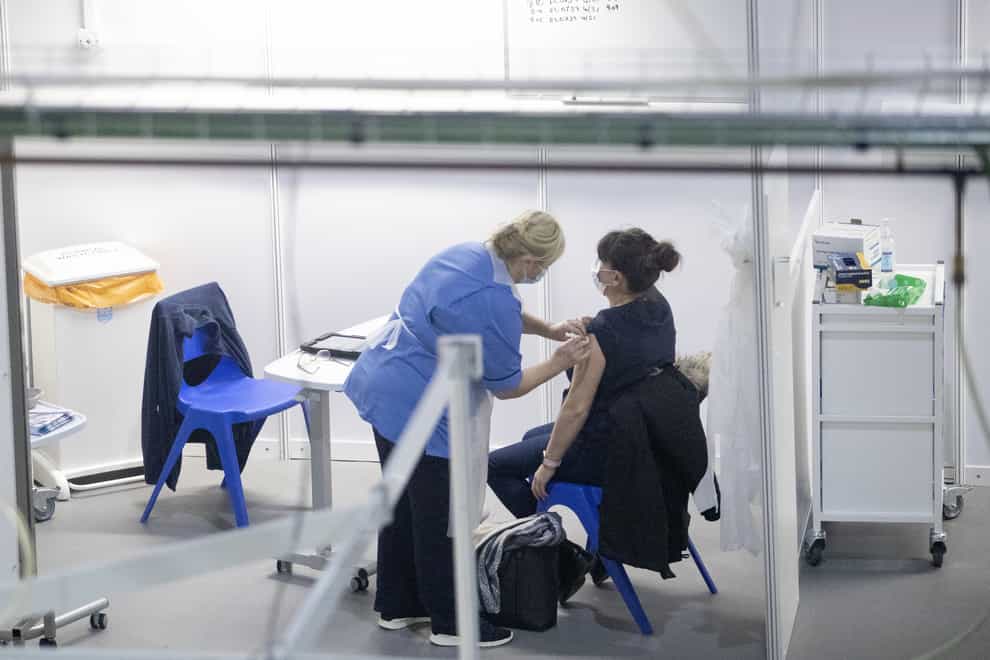 A nurse administers a coronavirus vaccine to a health and care staff member (PA)