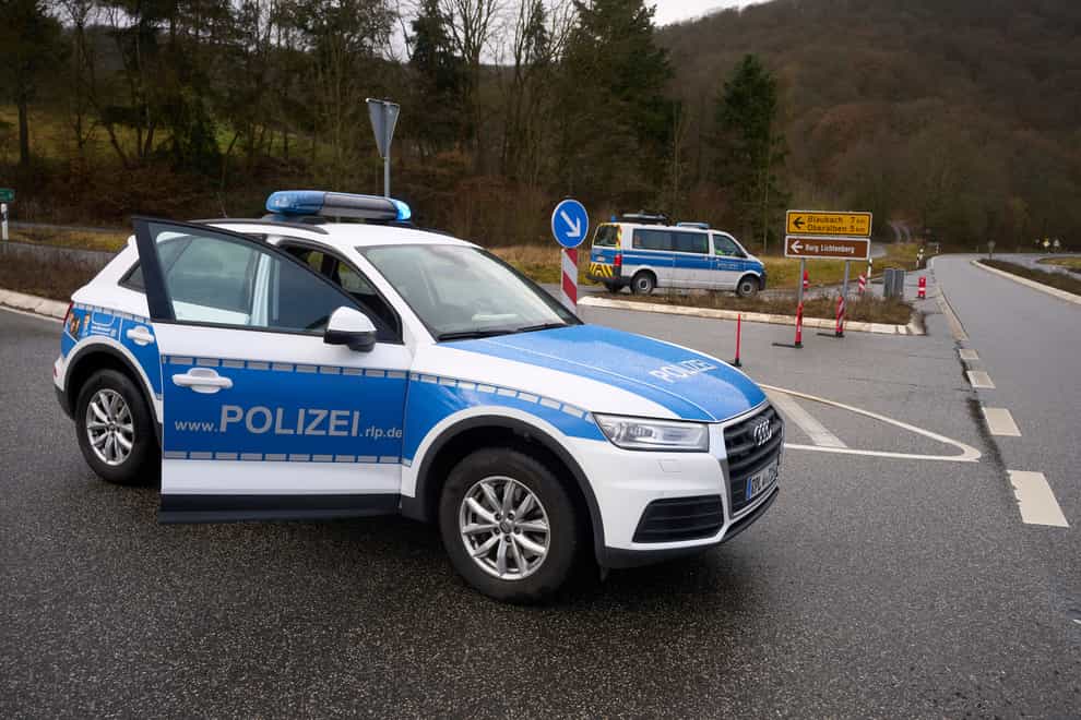 Police officers block the access road to the scene where two police officers were shot during a traffic stop near Kusel, Germany (Thomas Frey/dpa via AP)