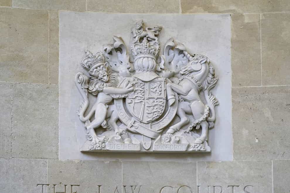 A stone carving of the royal coat of arms above a sign for The Law Courts outside the entrance to Bristol Crown Court (Andrew Matthews/PA)