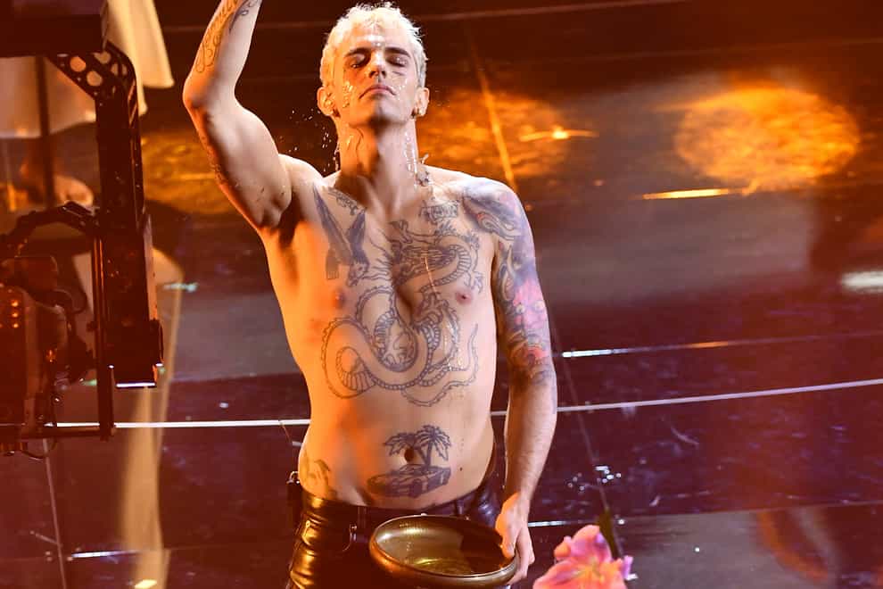 Achille Lauro performs what was called a “profane” faux baptism as he sings “Domenica” at the San Remo music festival in Sanremo, Italy, Tuesday, Feb. 1, 2022. An Italian bishop on Wednesday, Feb. 2, 2022, strongly protested the performance, denouncing both the singer and RAI state television for showing a “profane” faux baptism on stage. (Matteo Rasero/LaPresse via AP)