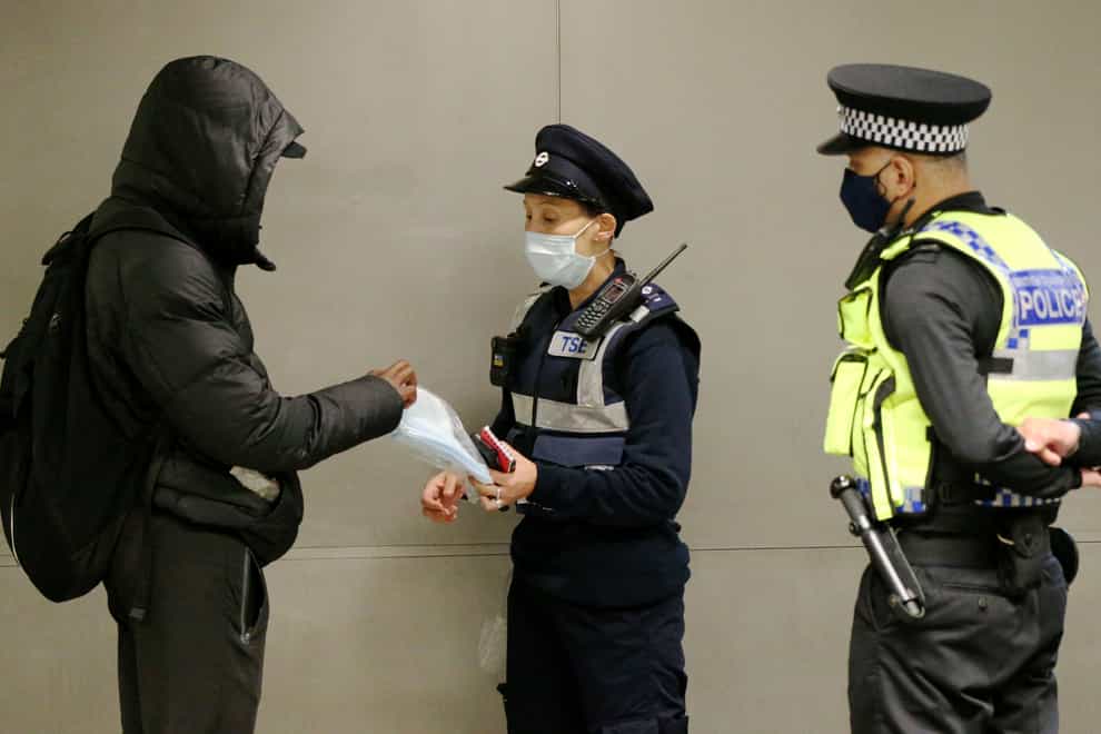 A man is given a face mask to wear after being issued with a fine for not being in possession of and not wearing a face mask (Jonathan Brady/PA)