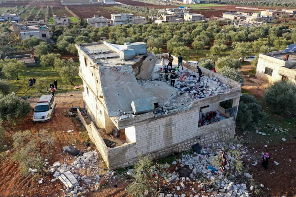 People inspect a destroyed house following an operation by the US military in the Syrian village of Atmeh, in Idlib province, Syria (Ghaith Alsayed/PA)
