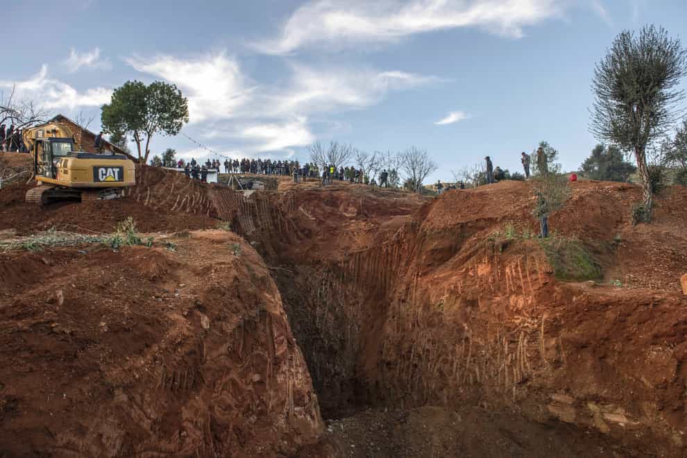 Rescue workers dig in a hill as they attempt to reach the five-year-old boy (AP)