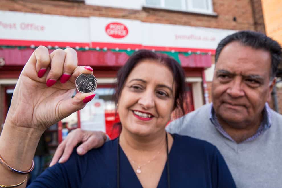 Postmaster Umesh Sanghani and his wife Rashmita as the new 50p coin to mark the Queen’s Platinum Jubilee is released (Post Office/PA)