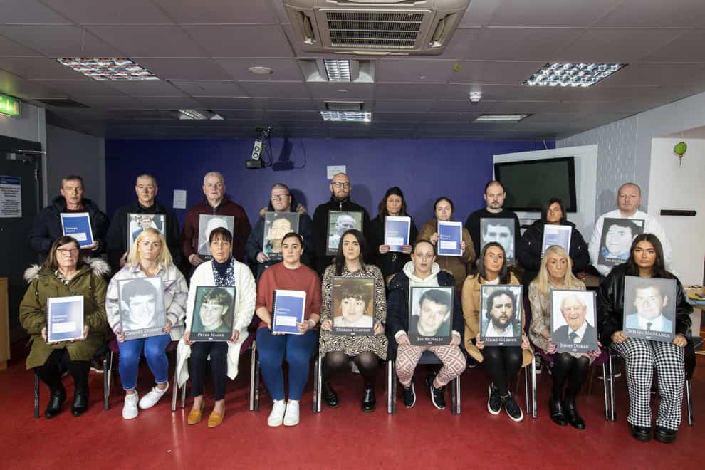 Family of those killed during the Troubles by loyalist paramilitaries in south Belfast pose together holding images of their loved ones and copies of the Police Ombudsman’s report into police handling of loyalist paramilitaries murders and attempted murders in south Belfast in the period 1990 to 1998, at Shaftesbury Recreation Centre, Ormeau Road, Belfast (Liam McBurney/PA)