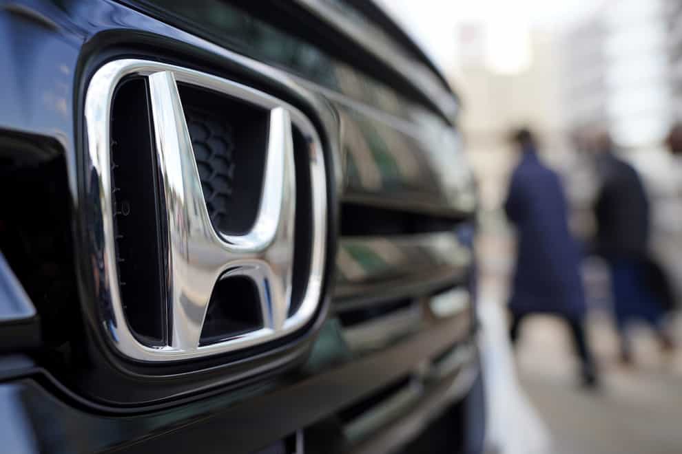 Honda has said its profit dropped 32% in the last quarter amid rising material costs and a shortage of computer chips (Eugene Hoshiko/AP)