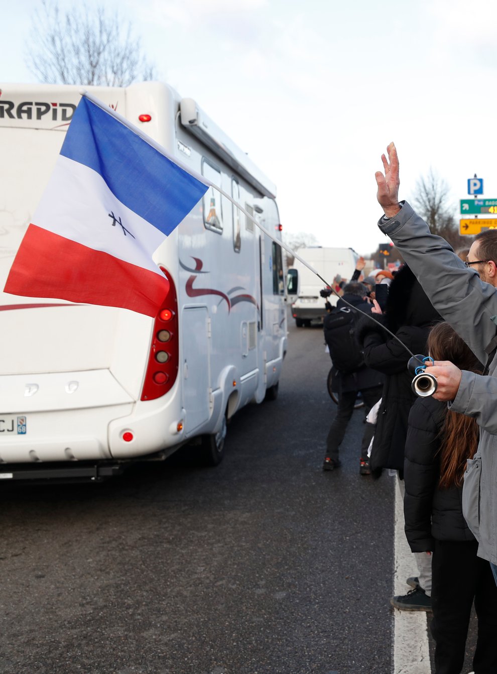 People wave to a convoy departing for Paris in Strasbourg, eastern France (AP Photo/Jean-Francois Badias)