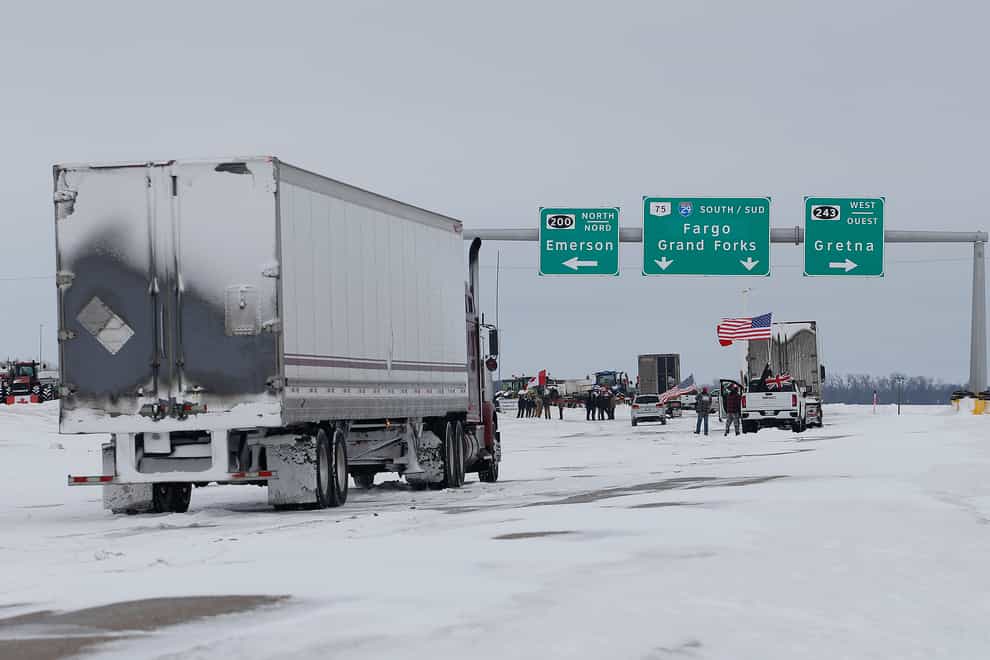 People block highway 75 with heavy vehicles and farm equipment and access to the Canada-United States border crossing at Emerson, Manitoba (John Woods/The Canadian Press via AP)