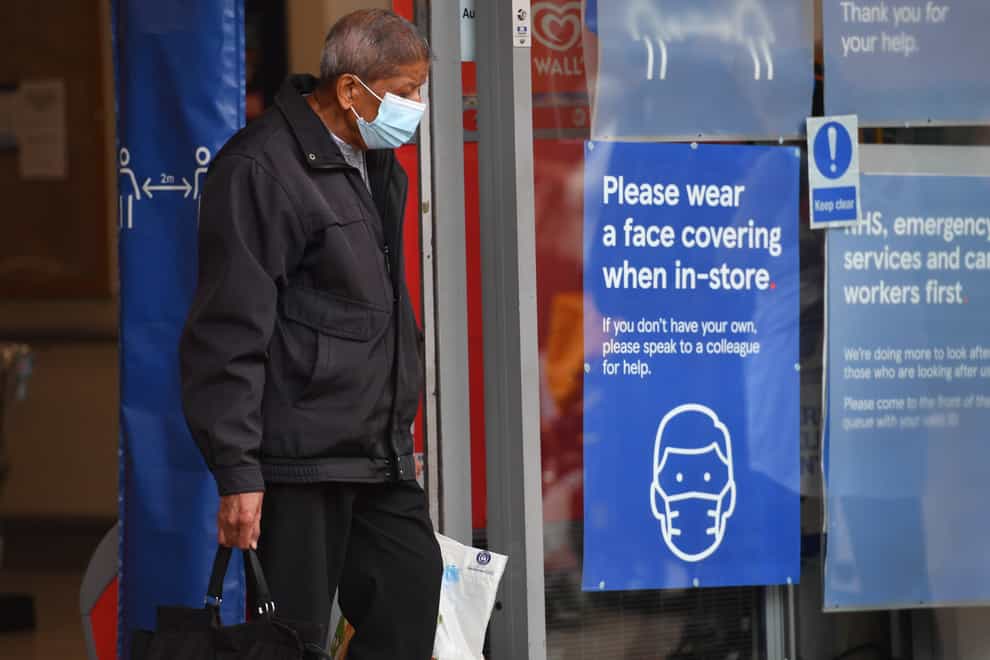 A shopper wearing a face mask leaves Tesco in Leicester city centre (Jacob King/PA)