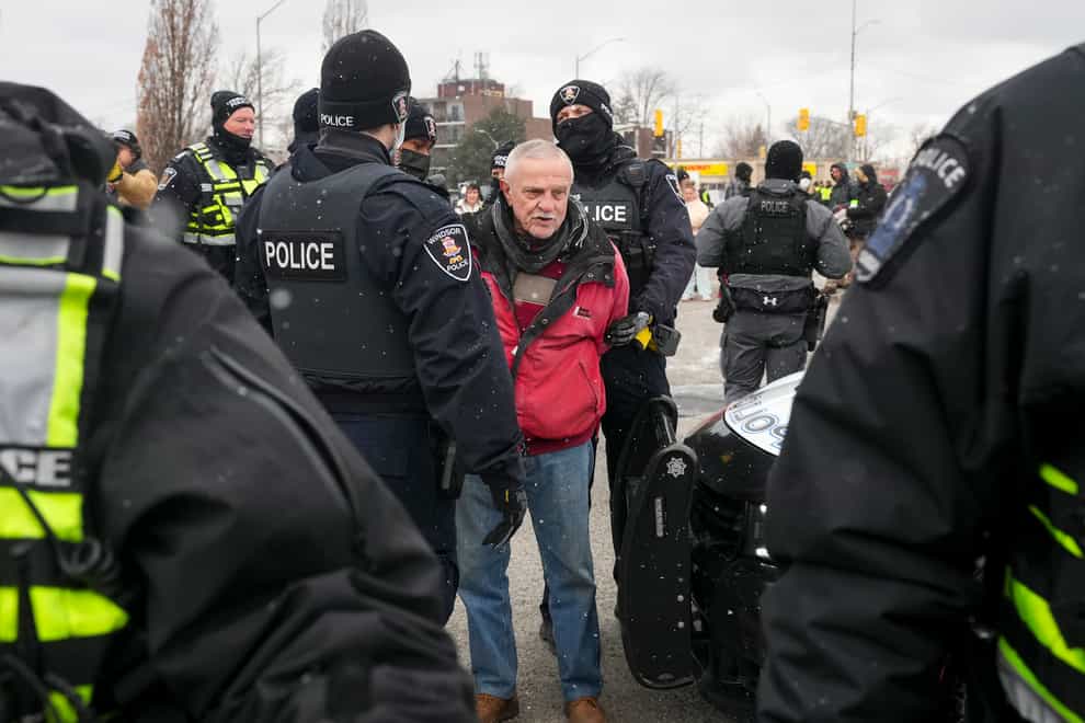 A protester is arrested as police remove truck drivers and supporters at the Ambassador Bridge linking Detroit and Windsor (Nathan Denette/The Canadian Press via AP)