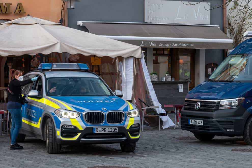 Police vehicles are stand in front of a restaurant in the city of Weiden, Germany (dpa via AP)