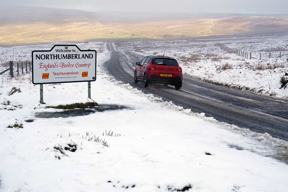 Cars navigating fresh snowfall on the A689 Road near Nenthead in Northumberland, as high winds are due to batter the UK (PA)