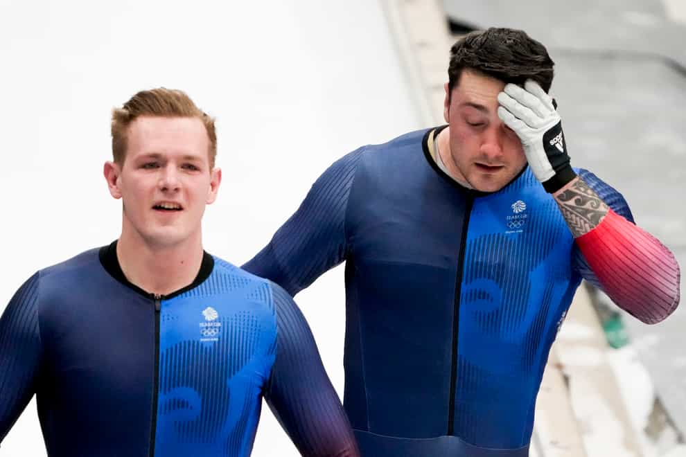 Great Britain’s Brad Hall and Nick Gleeson walk down the track after overturning during their third run i the two-man bobsleigh (AP/Mark Schiefelbein).