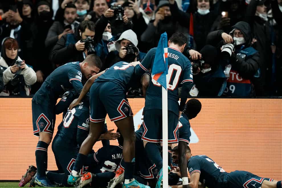Kylian Mbappe is mobbed by his Paris St Germain team-mates after his stoppage-time winner (Thibault Camus/AP)