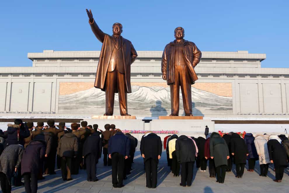 Citizens pay tribute to the statues of their late leaders Kim Il Sung, left, and Kim Jong Il on Mansu Hill in Pyongyang, North Korea on the occasion of the 80th birth anniversary of Kim Jong Il on Wednesday, Feb. 16, 2022. (AP Photo/Jon Chol Jin)